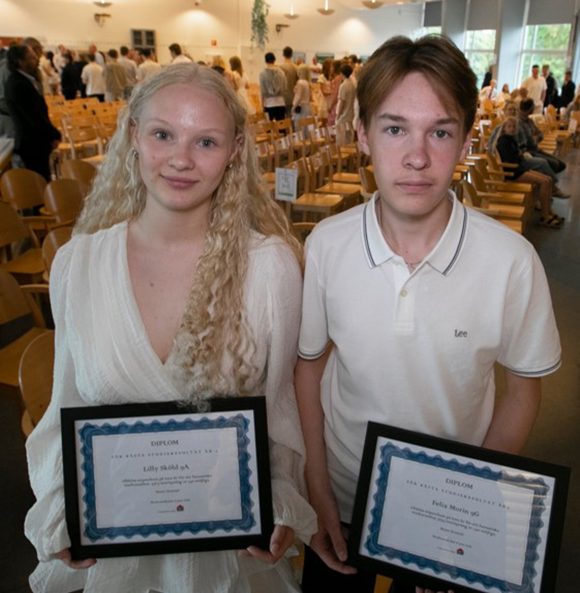 En tjej och en kille med varsitt diplom